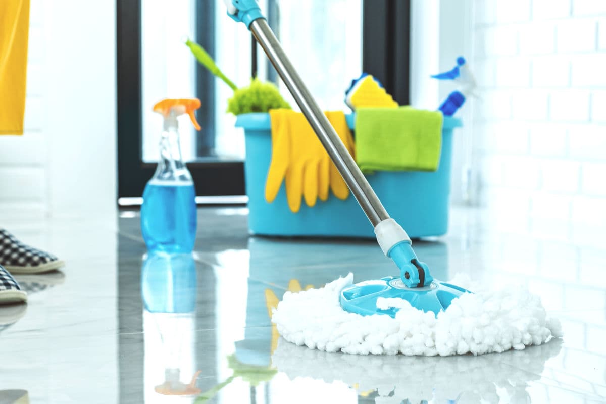 Mop and cleaning bucket on the floor, seasonal deep cleaning for kitchens and bathrooms.